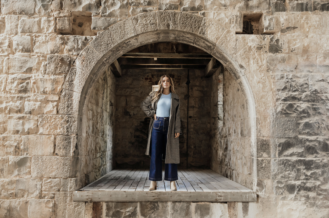 Model standing in an archway wearing Foxwood clothing.